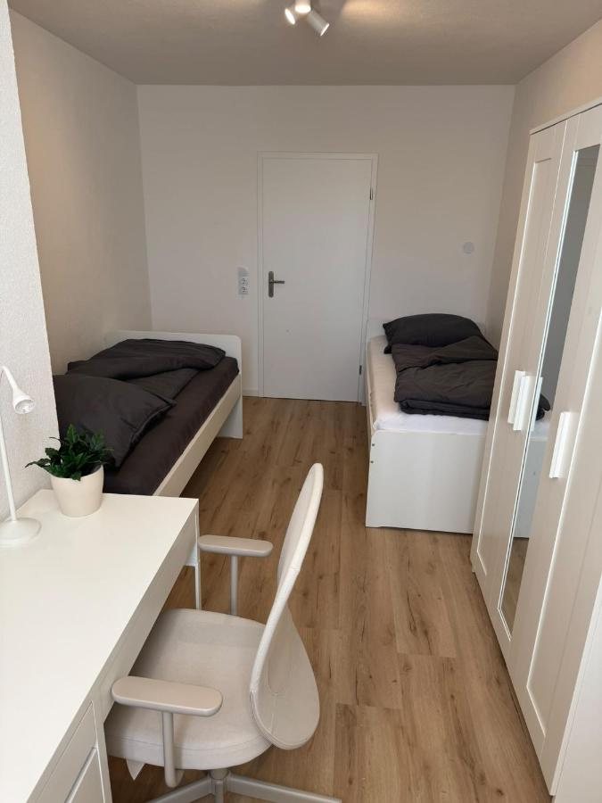 Zimmer mit zwei Einzelbetten und Schreibtisch